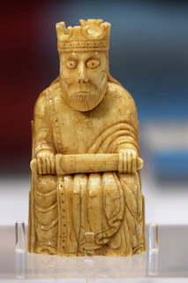 A detailed illustration of the King of Swords tarot card, showing a wise king seated on a throne with a sword held upright.