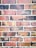 An arrangement of weathered red and dark gray bricks with visible mortar lines, showcasing a rustic and textured pattern.