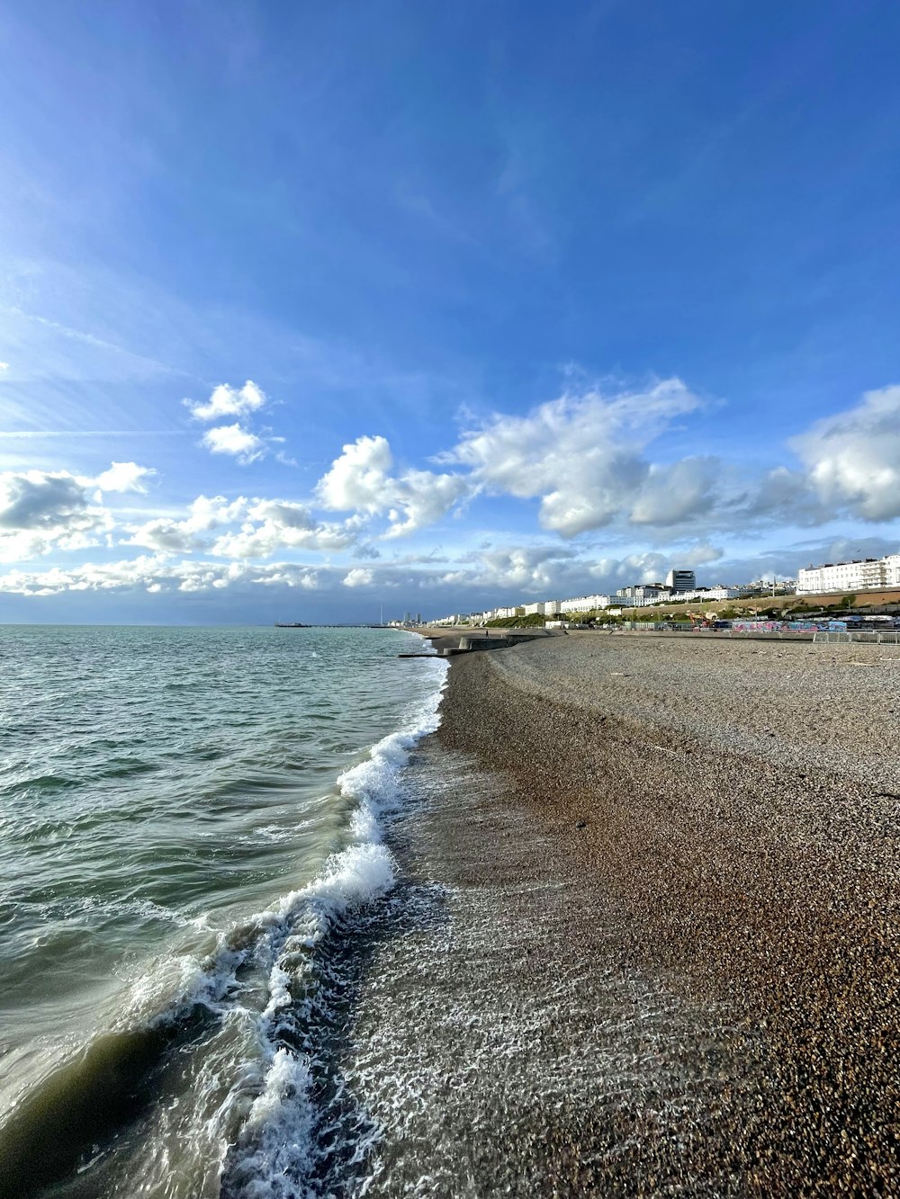 a sandy beach with waves coming in to shore