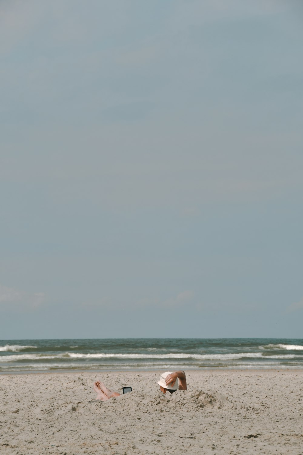 a person laying in the sand on a beach