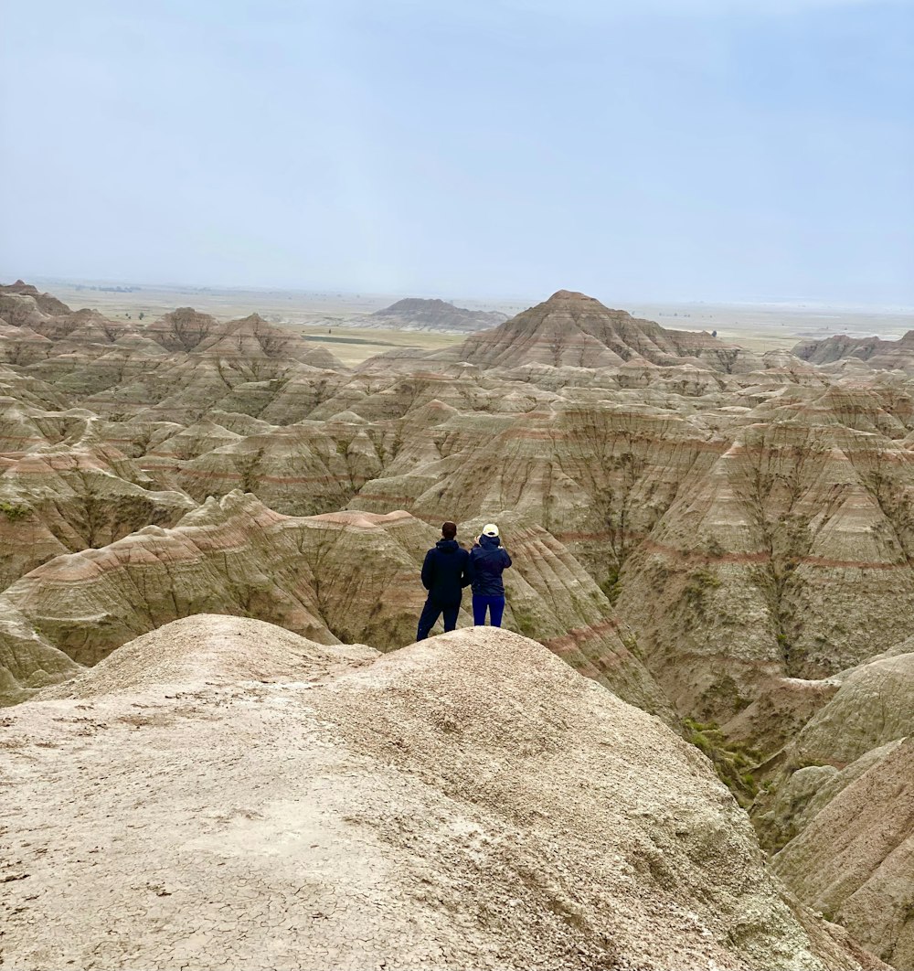 a couple of people standing on top of a mountain