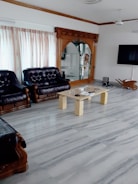 A spacious living room with marble flooring and modern decor.