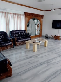 A spacious living room showcasing polished marble flooring installed by a skilled craftsman.