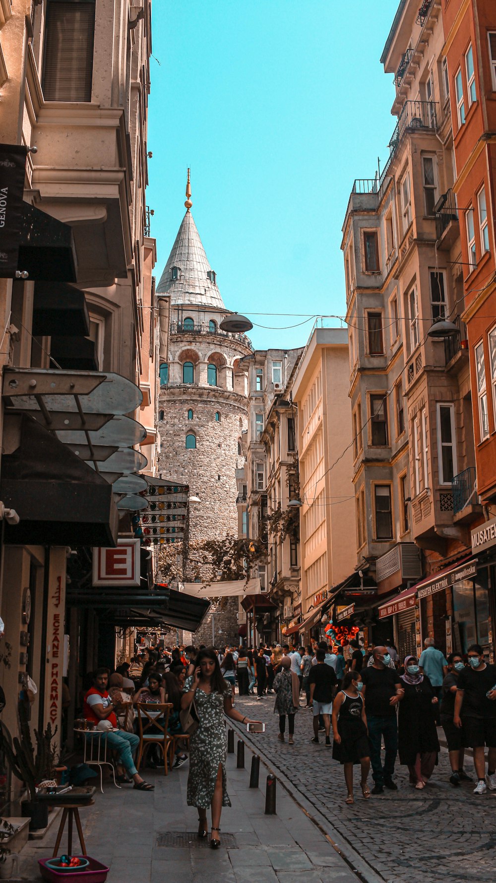 a group of people walking down a street next to tall buildings