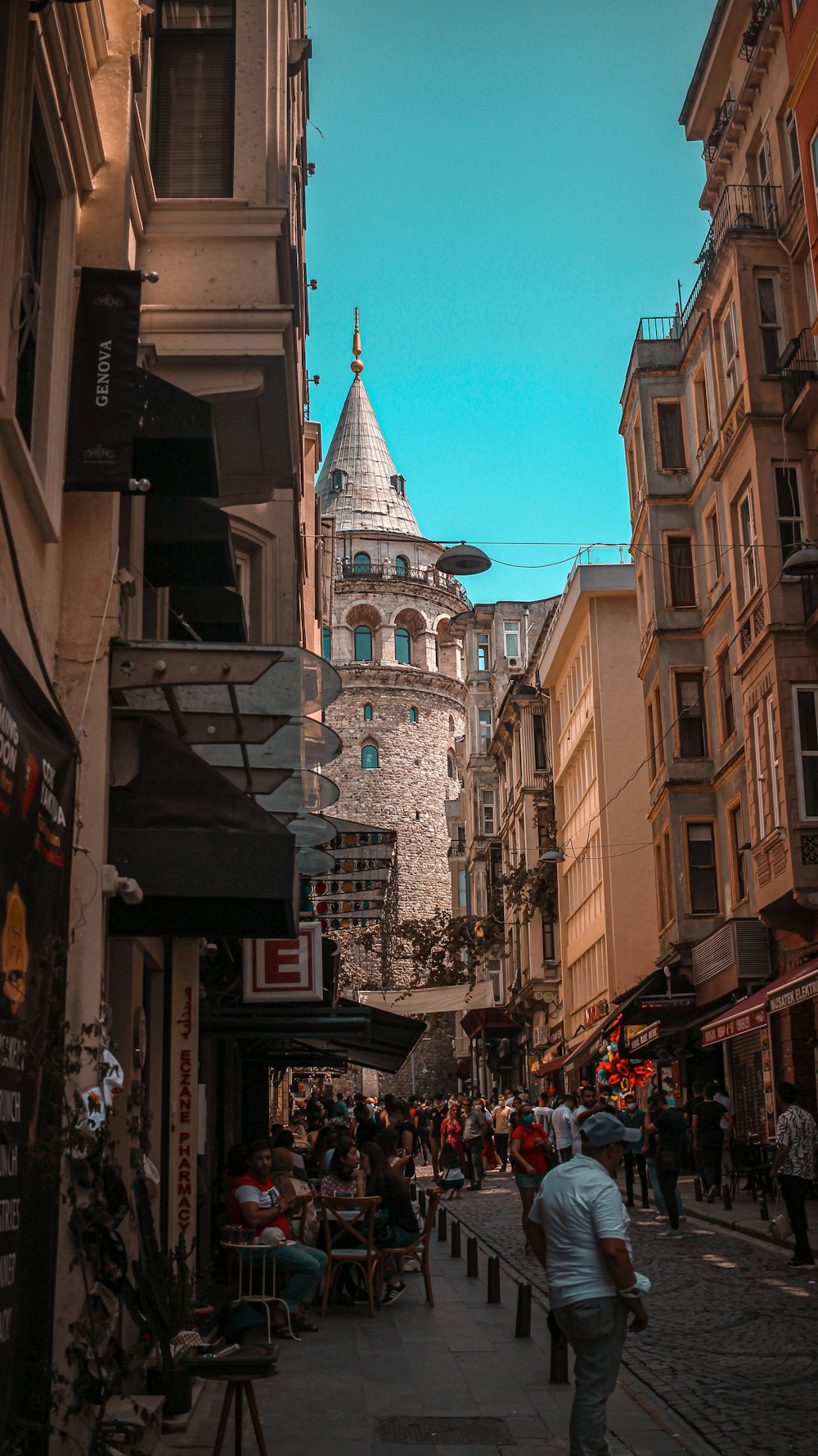 a narrow city street with people walking around