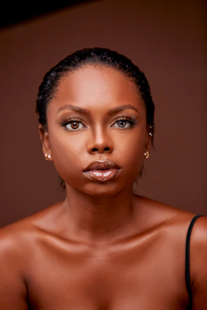 Close-up of a stylish Black woman with a sleek pixie cut in soft natural light.