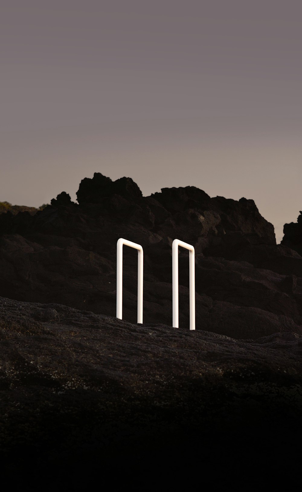 a couple of white poles sitting on top of a hill