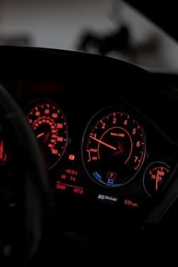 the dashboard of a car with red and white lights