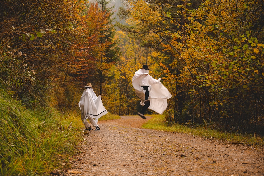 a couple of people that are walking down a dirt road