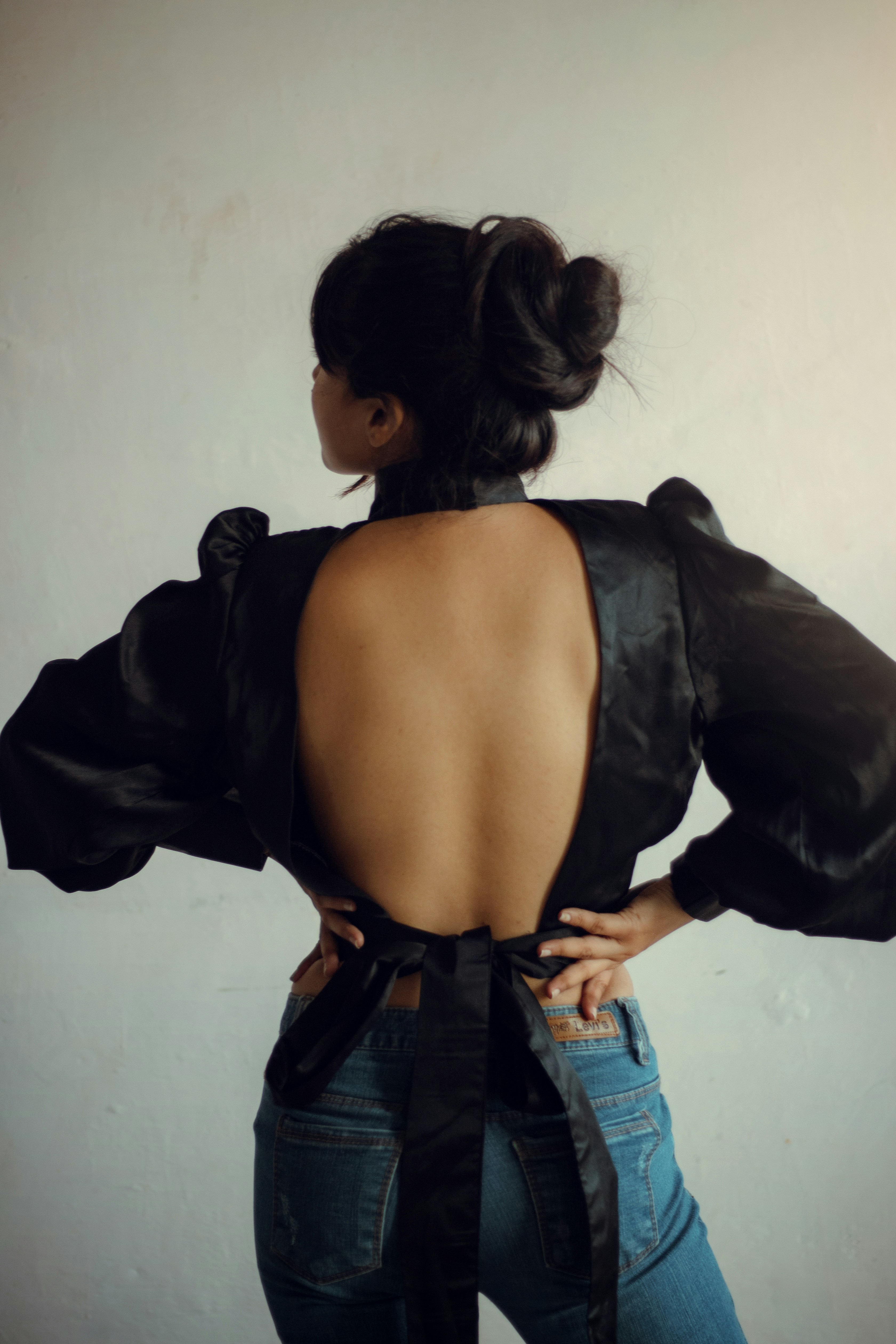 uma mulher vestindo um top preto e jeans
