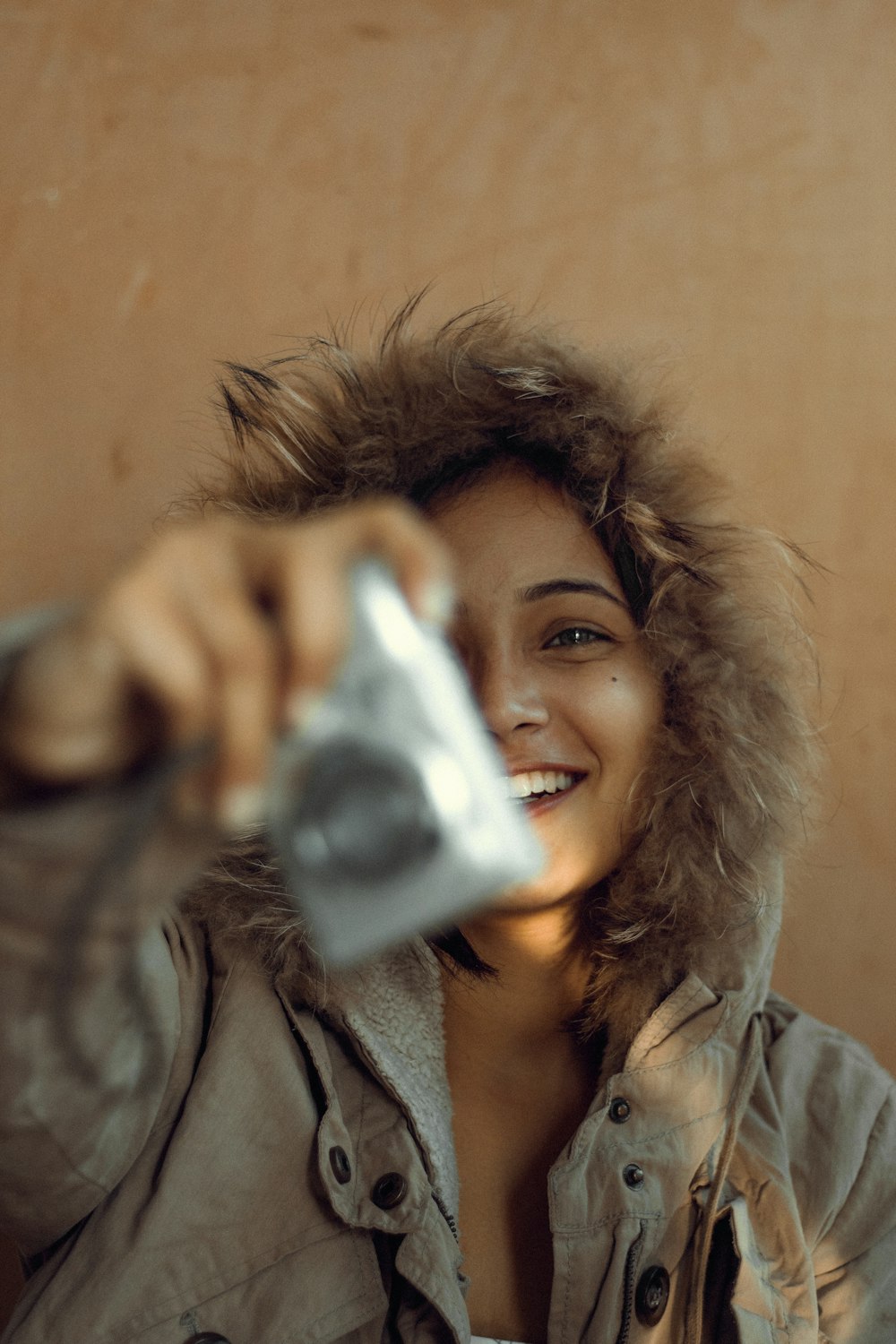 a woman is smiling and holding a camera