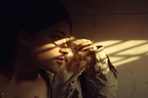 Portrait of a thoughtful person sharing a story in soft yellow light.