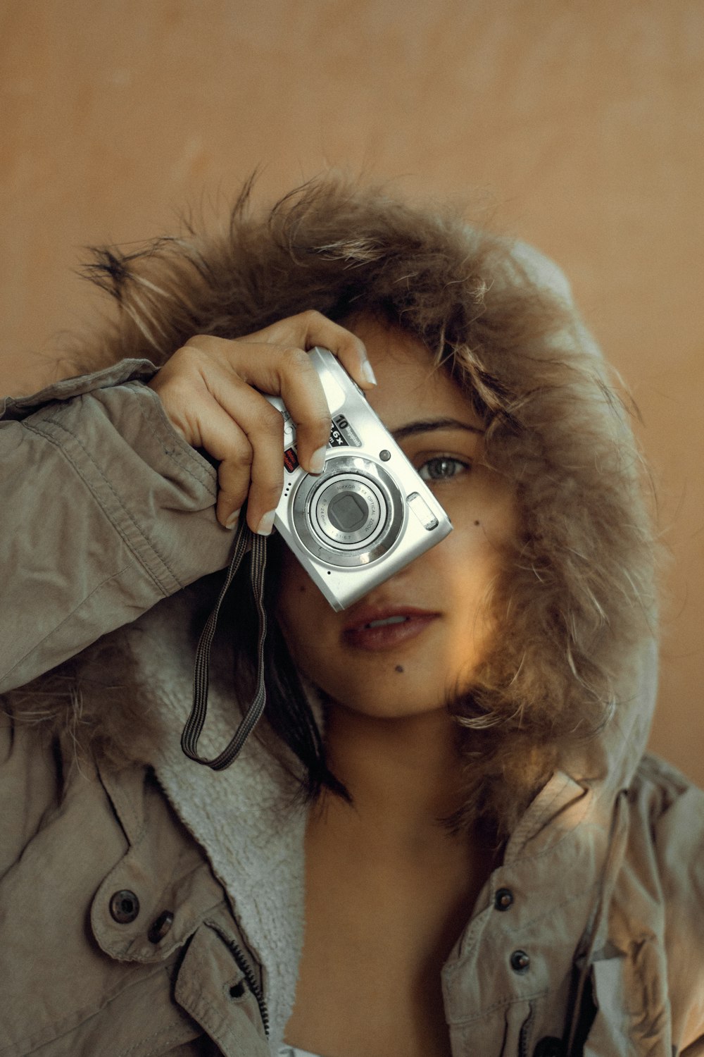 a woman holding a camera up to her face