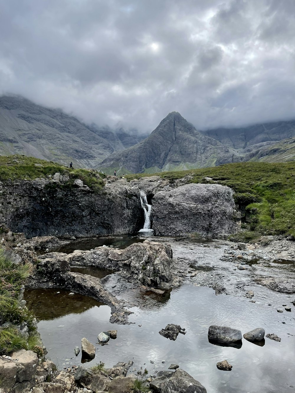 a stream running through a lush green valley