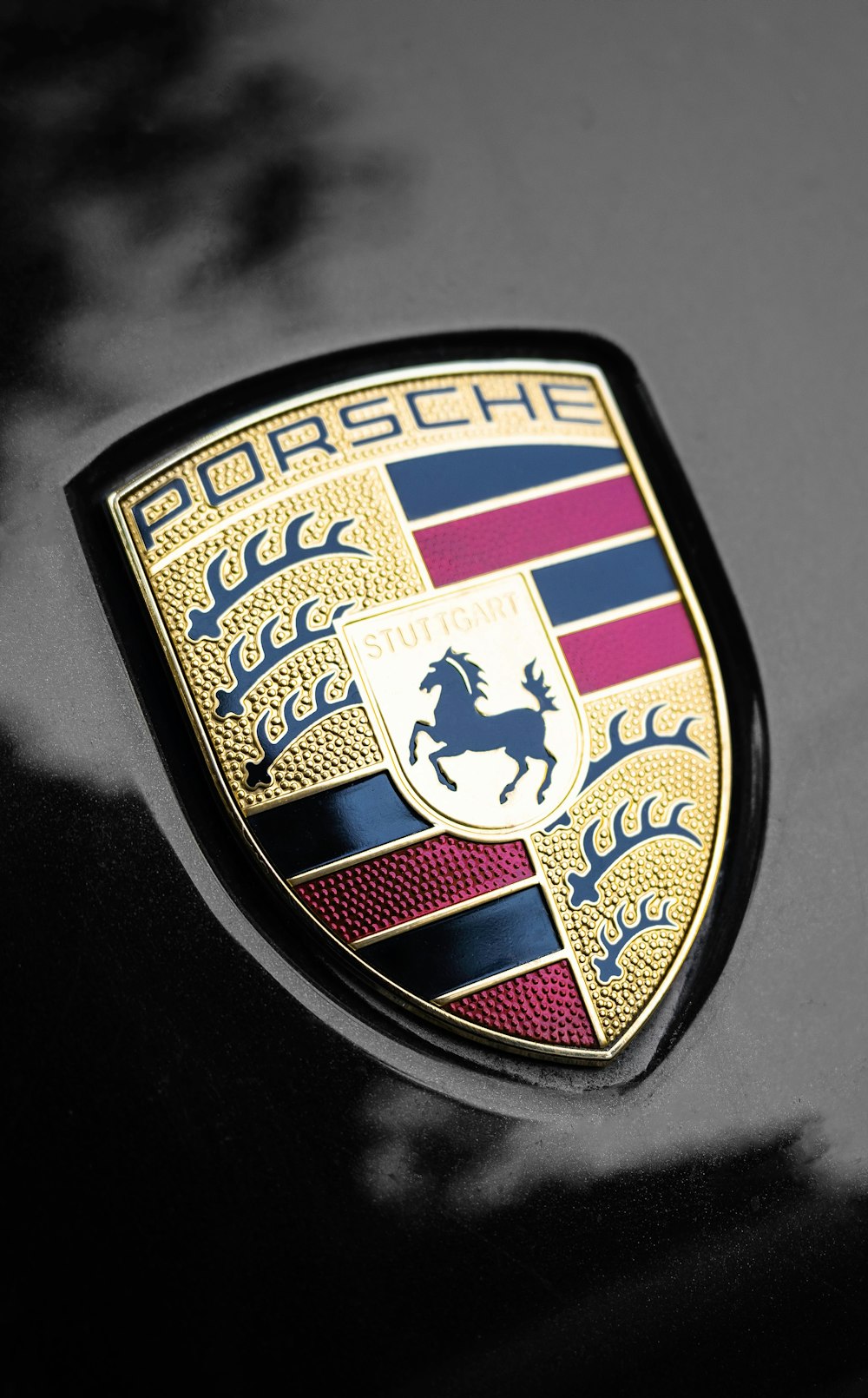 Nahaufnahme eines Porsche-Emblems auf einem Auto