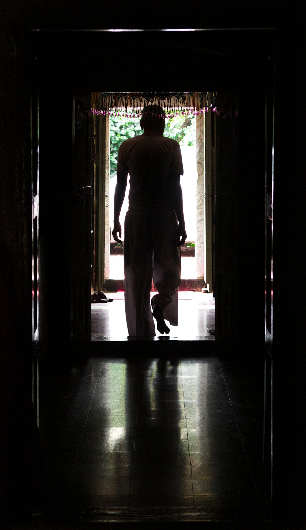 a man walking into a doorway with a dog