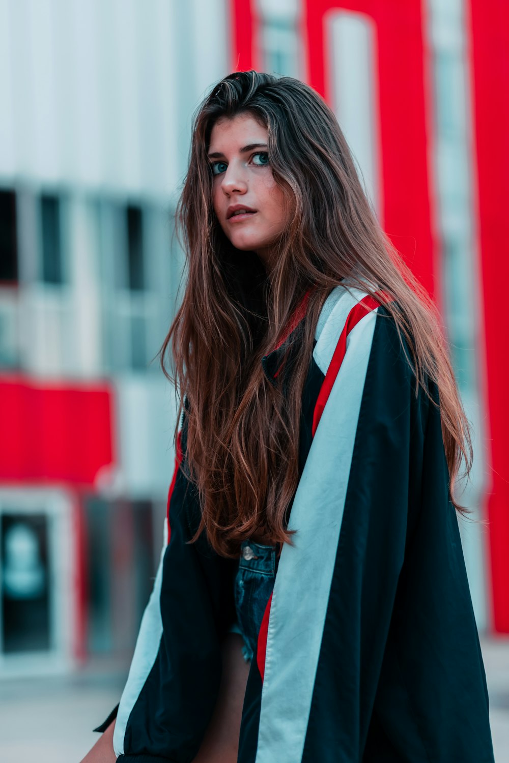 a woman with long hair standing in front of a building