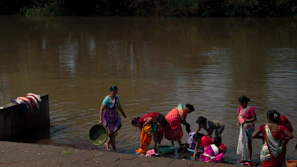 Community health worker explaining menstrual hygiene practices to a group of attentive women outdoors