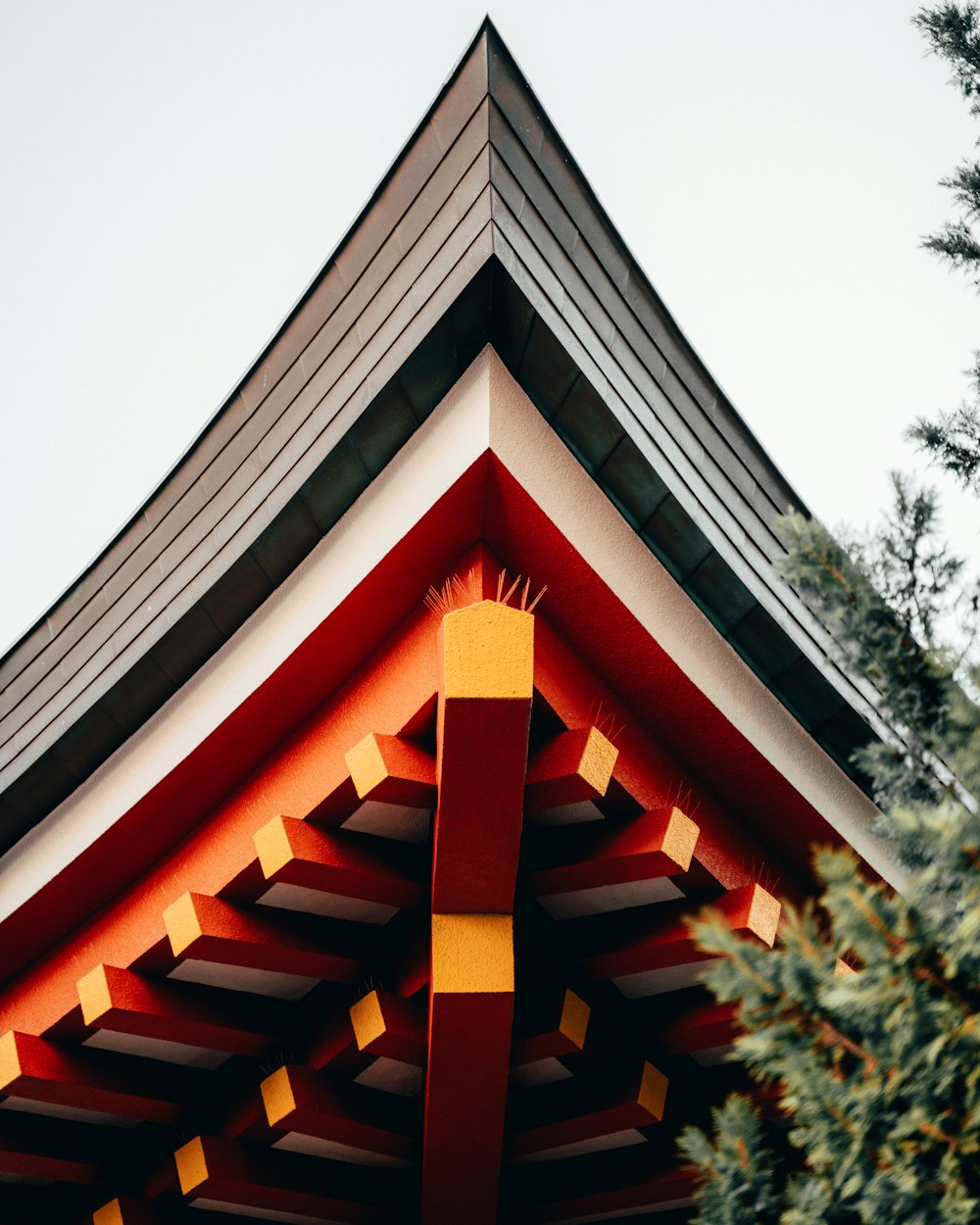 a red and yellow building with a tree in front of it