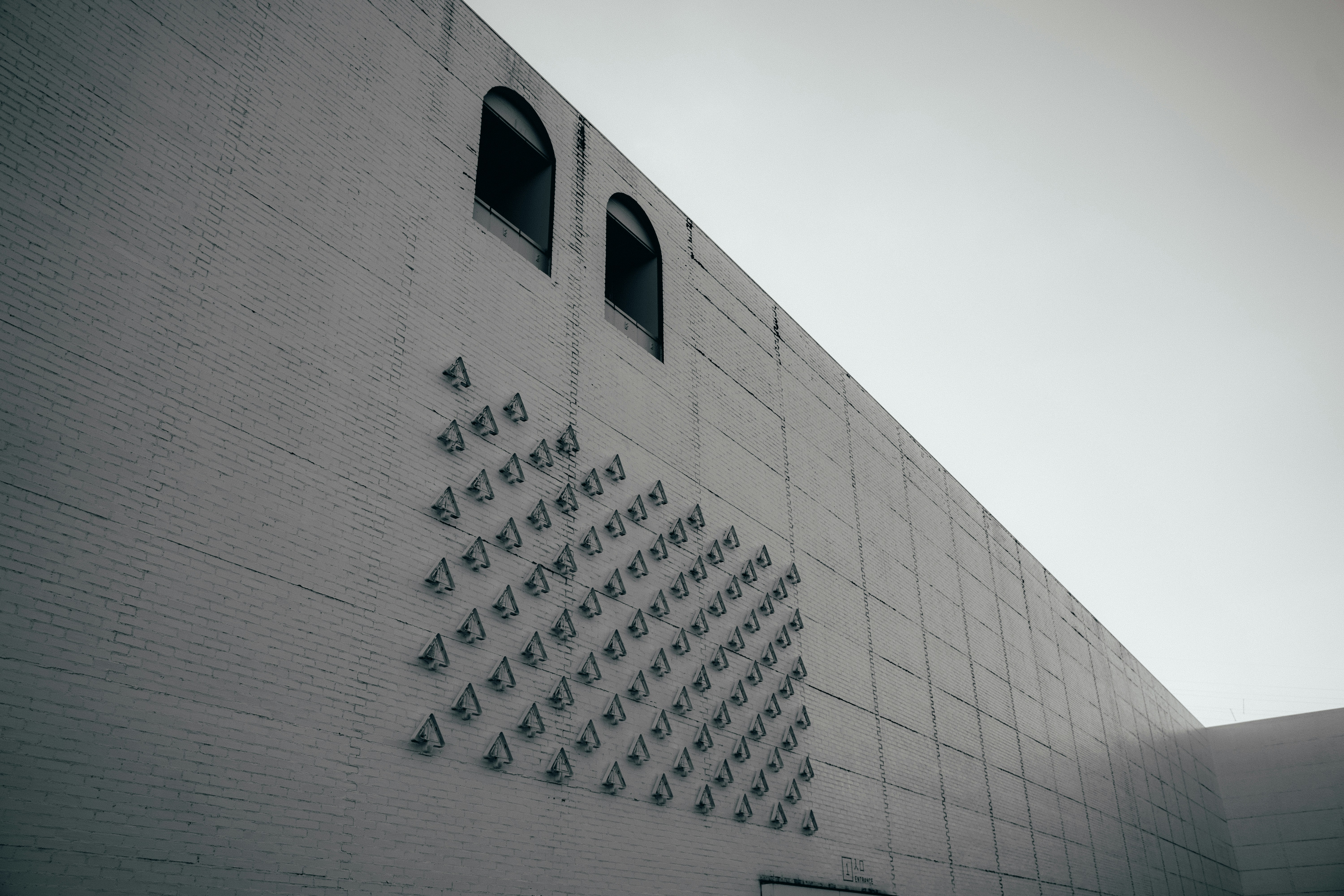 a white brick building with a clock on the side of it