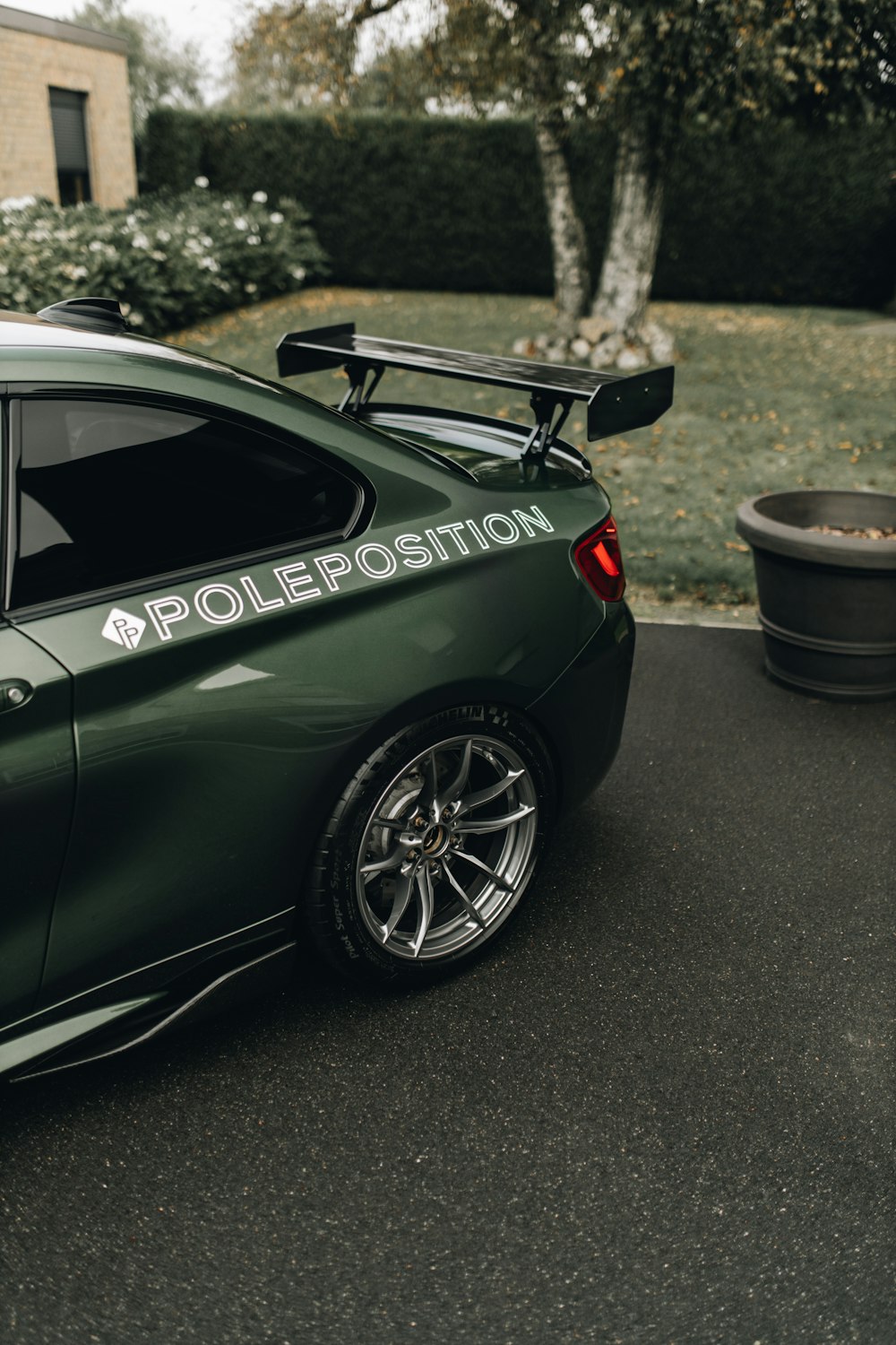 a green car parked in front of a house