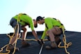 a couple of men working on a roof