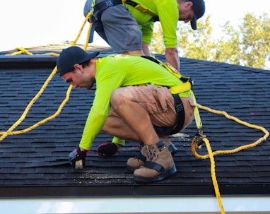 two men working on the roof of a house