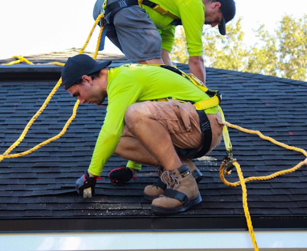 two men working on the roof of a house