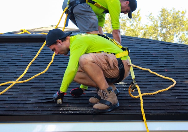two men working on the roof of a house