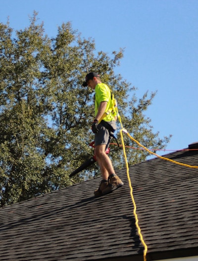 a man on a roof working with a rope