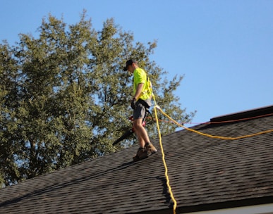 a man on a roof working with a rope