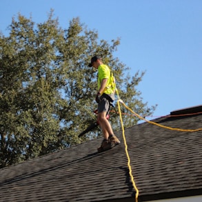 a man on a roof working with a rope