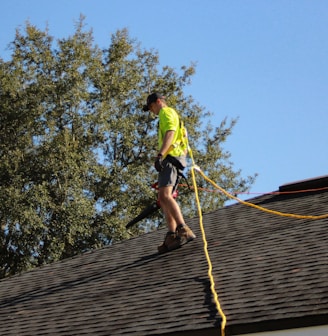 a man on a roof working with a rope