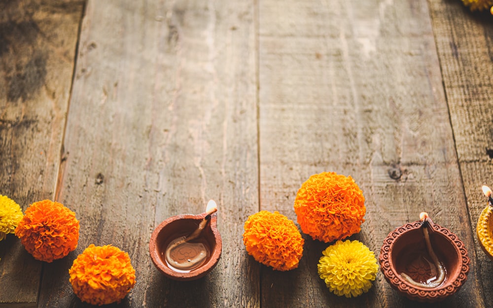 a wooden table topped with orange and yellow flowers