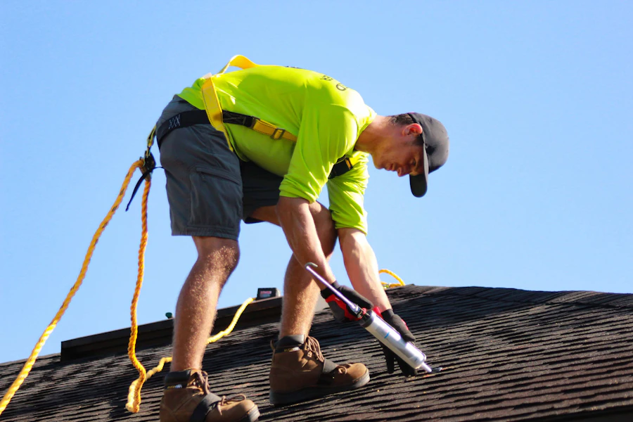 Roofer hammering shingles on a residential home