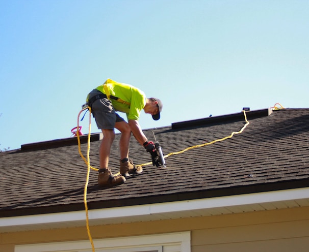 a man working on a roof with a power drill