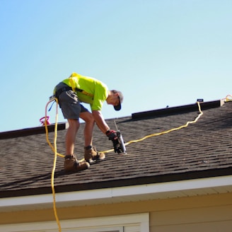 a man working on a roof with a power drill