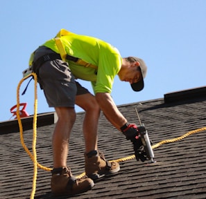 a man working on a roof with a power drill