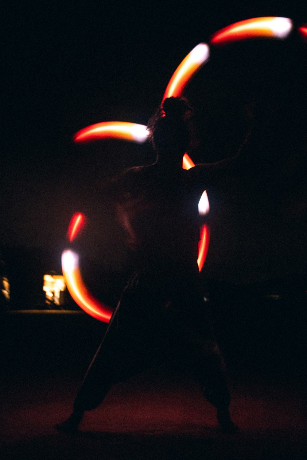 Eine Person, die mit einem Hula-Hoop-Reifen im Dunkeln steht