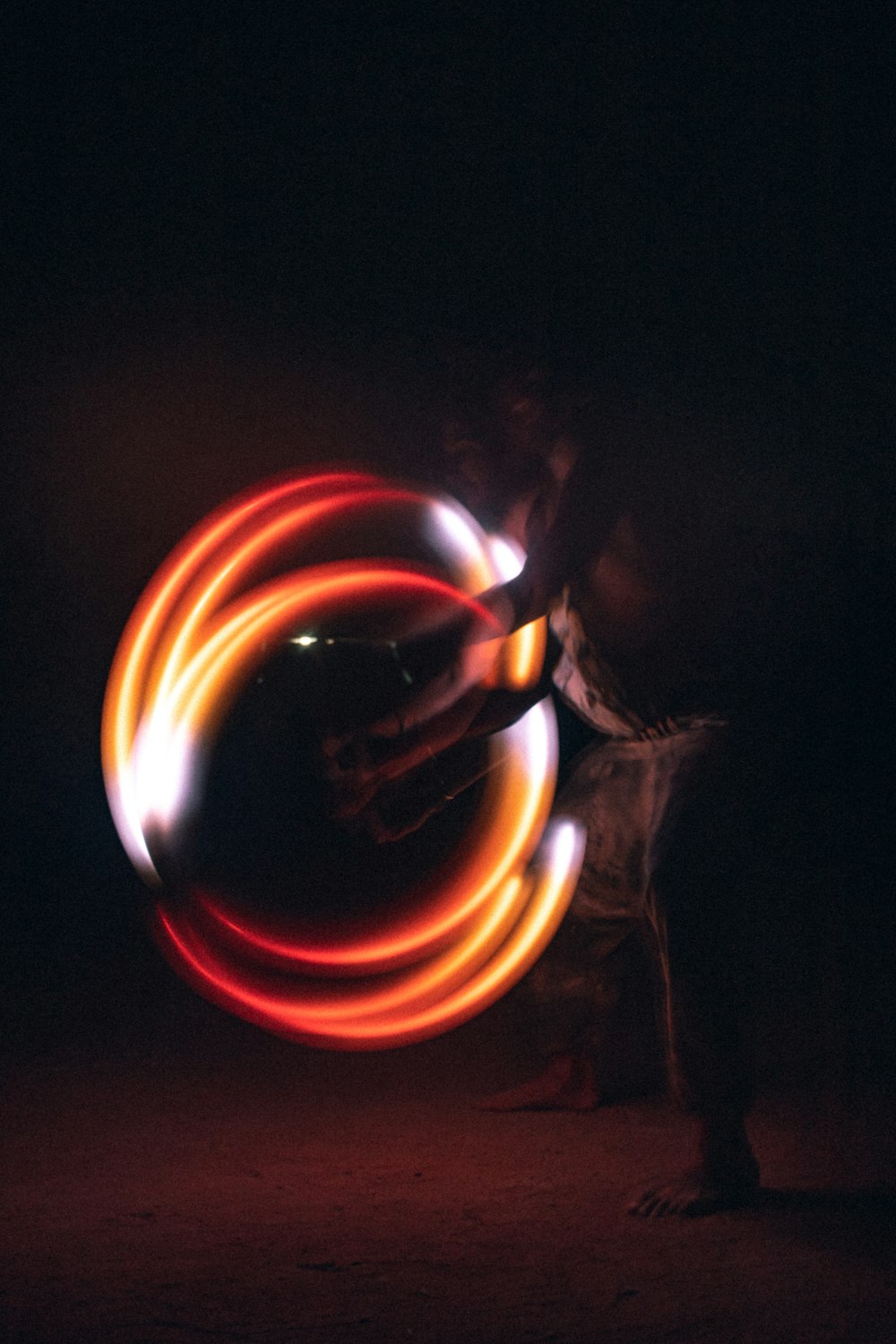 Ein Mann dreht ein kreisförmiges Licht im Dunkeln