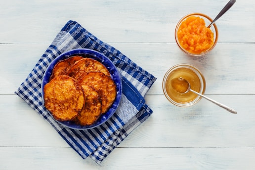 a blue plate topped with food next to a glass of orange juice