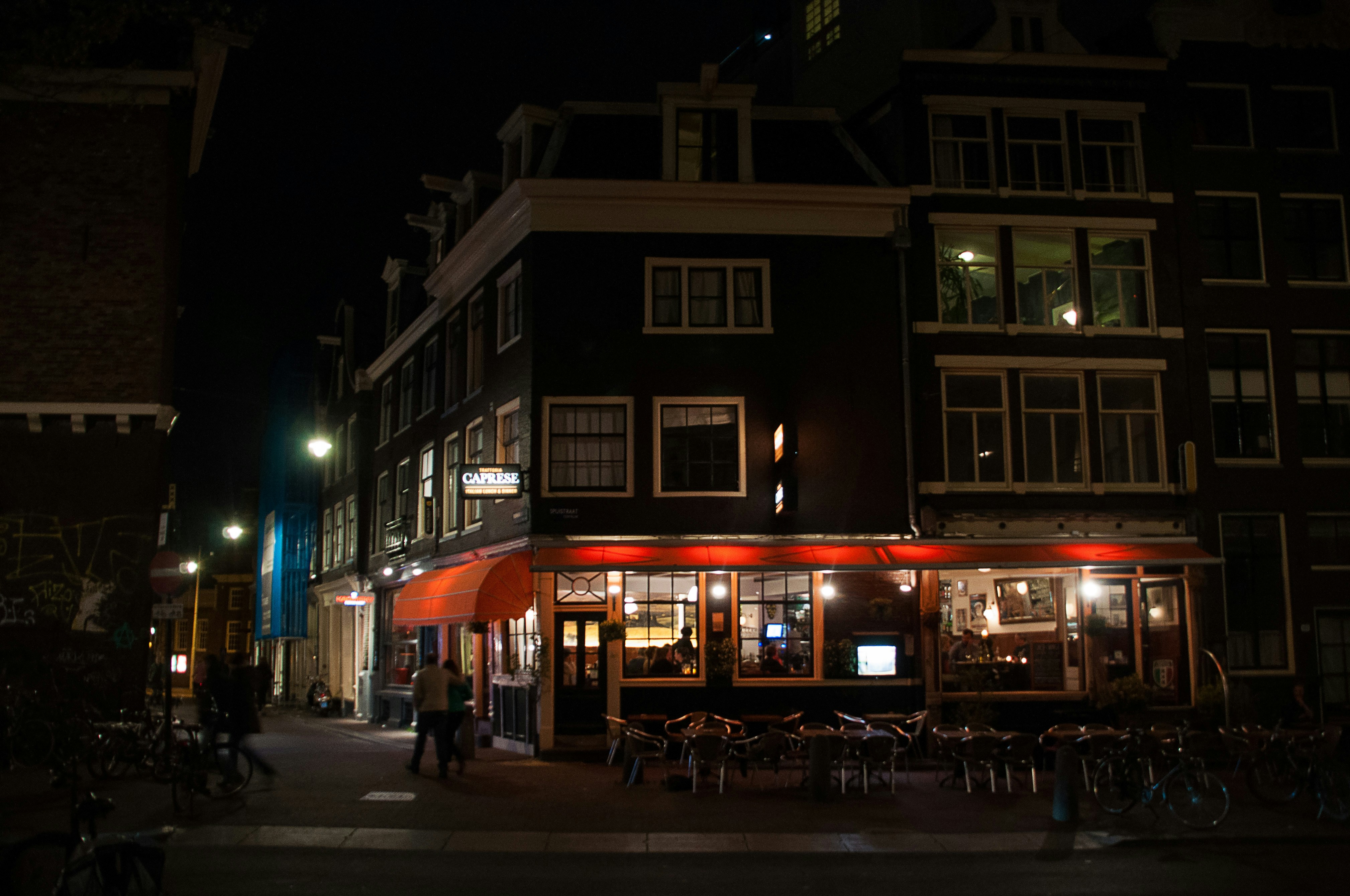 a dark city street at night with people walking by