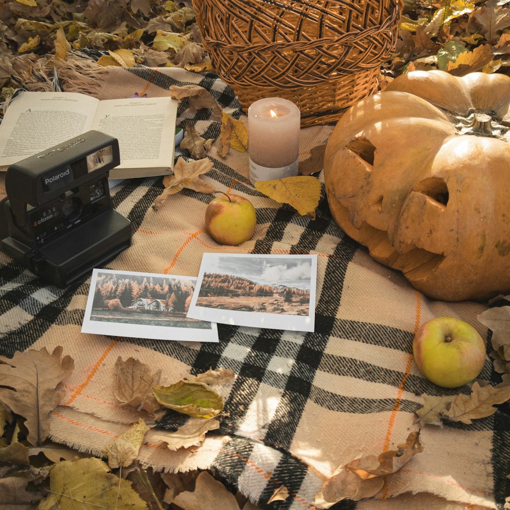 a table topped with pumpkins and a camera