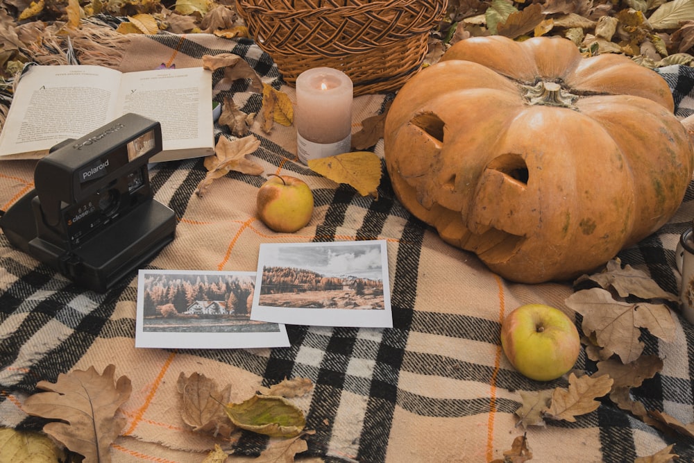 a table topped with a camera and a pumpkin