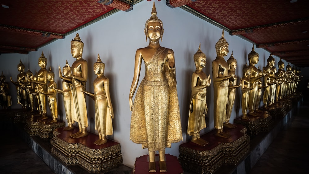 Una fila di statue dorate di Buddha sedute l'una accanto all'altra