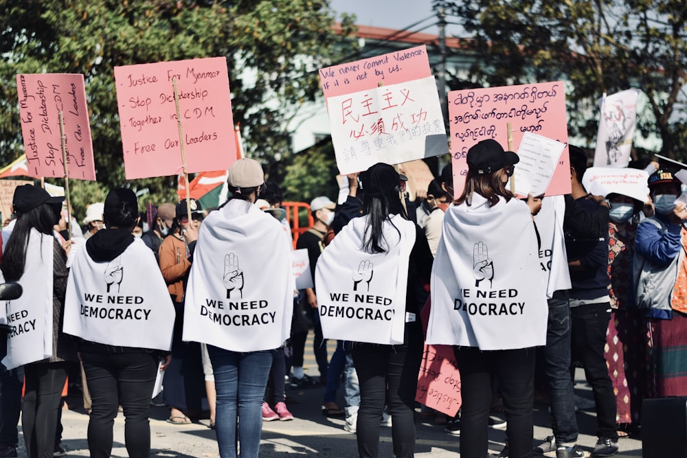 a group of people holding up signs in the street