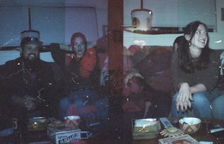Family gathered on a couch enjoying a movie night with neon-lit room ambiance.