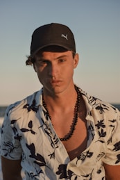 a man with a baseball cap on standing on a beach