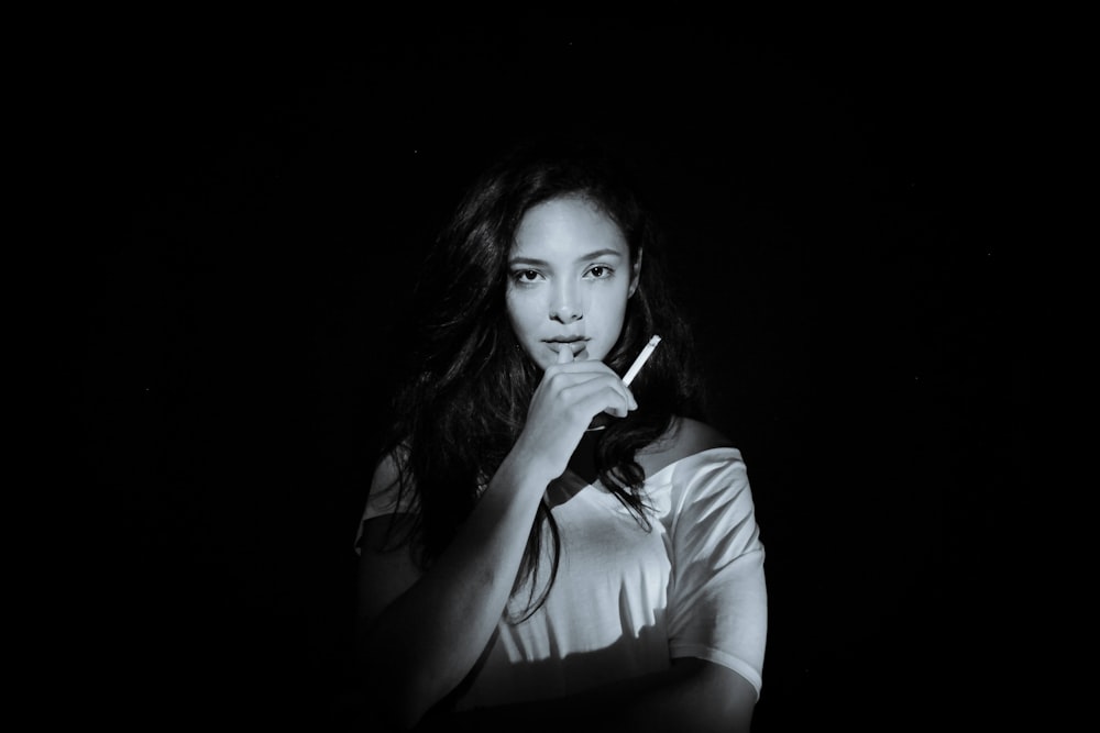 a black and white photo of a woman smoking a cigarette