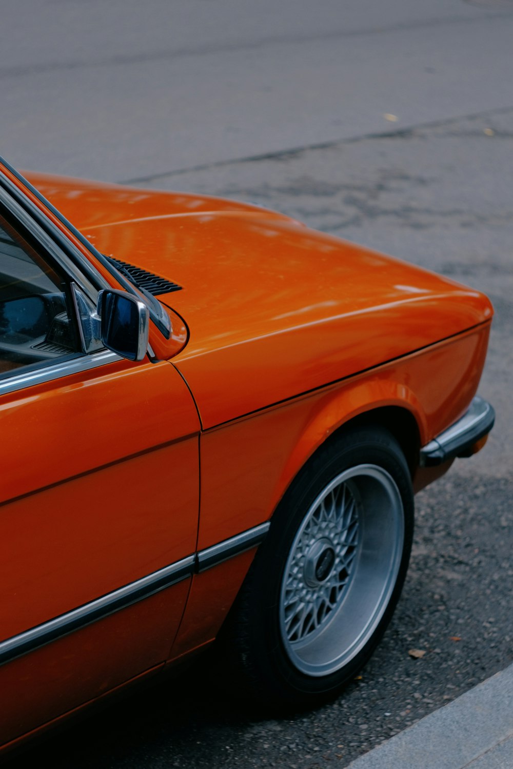 an orange car parked on the side of the road